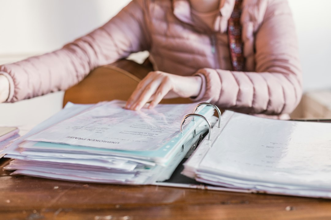 Conseillère immobilière indépendante préparant un dossier comptable avec factures et calculatrice