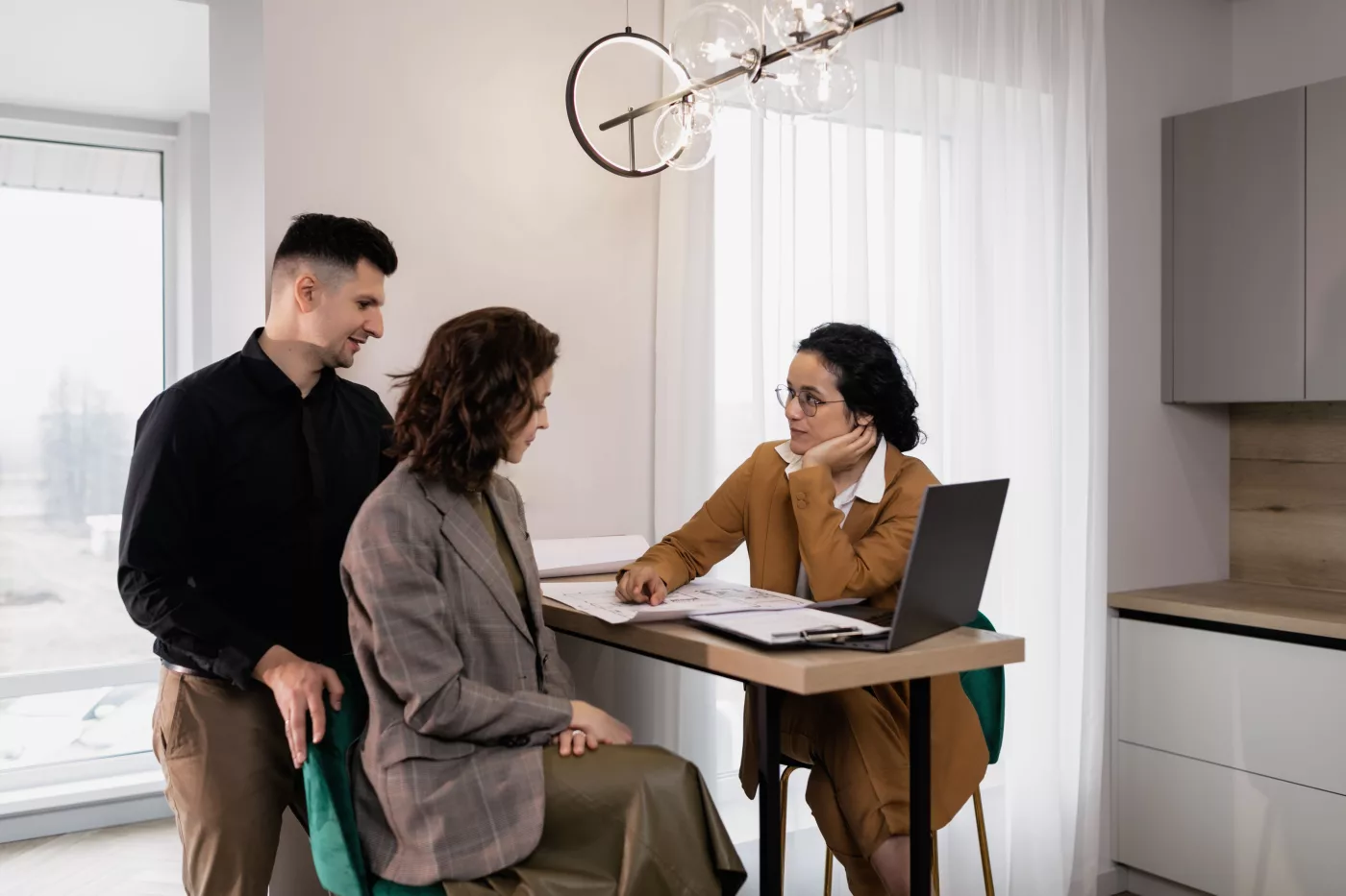 Couple acheteur examinant un calendrier de signature immobilière avec son conseiller
